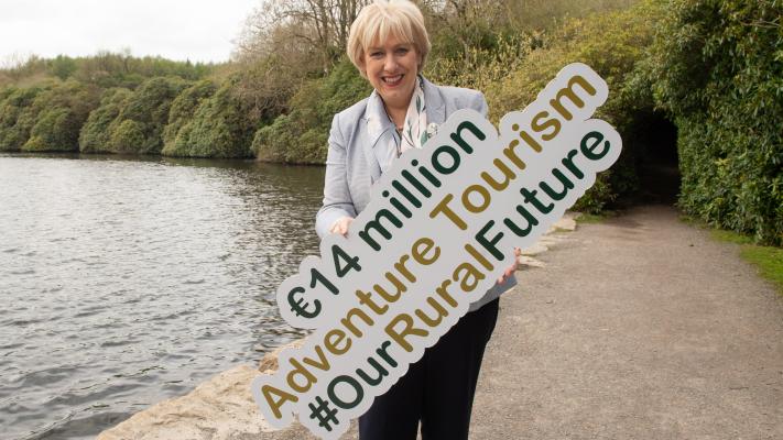 Heather Humphreys holding a sign that reads, "€14 million Adventure Tourism #OurRuralFuture".