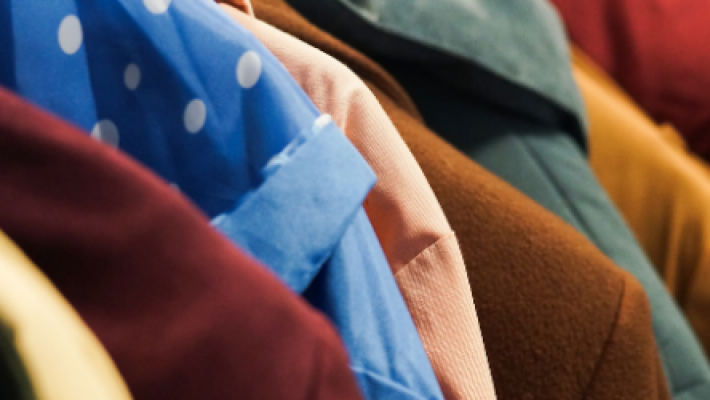 An image of some coats hanging on a rack.