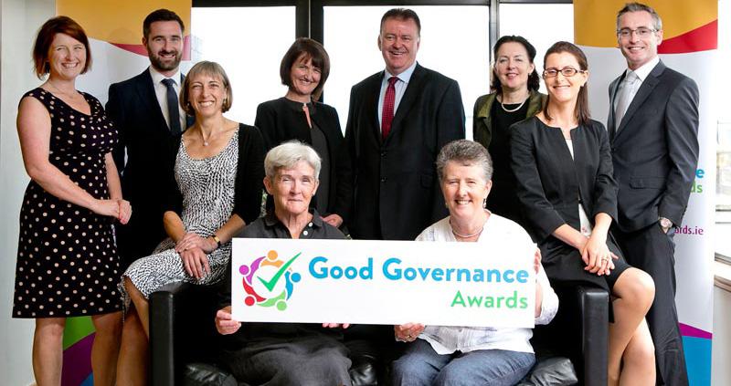An image of a group of people holding a banner for the Good Governance Awards, representing a selection of the Judging Panel from the first year of the Good Governance Awards, 2016.