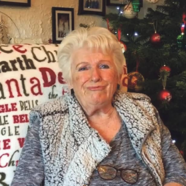 A photo of Noelle, sitting by a Christmas tree.