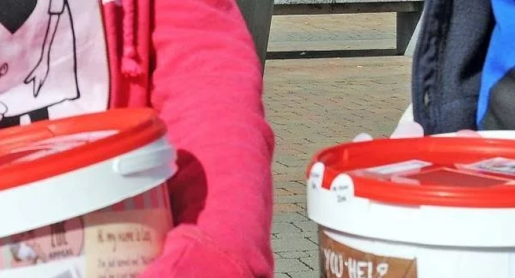 An image of volunteers collecting money in buckets.