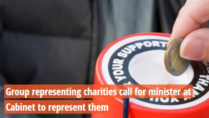 Hand putting coin into donation bucket.