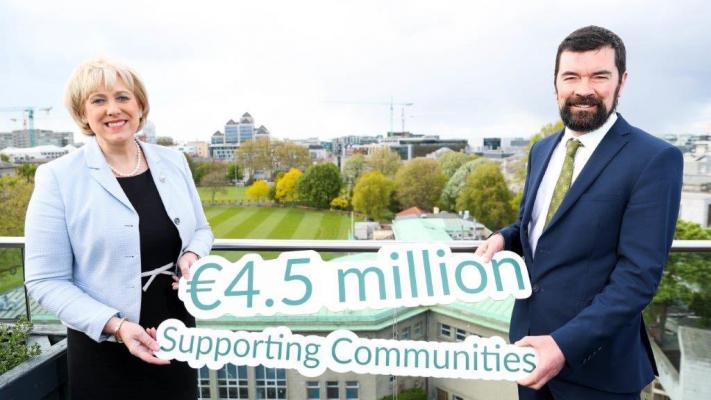 Minister and Minister of State from the DRCD holding a sign that says, "€4.5 million Supporting Communities".
