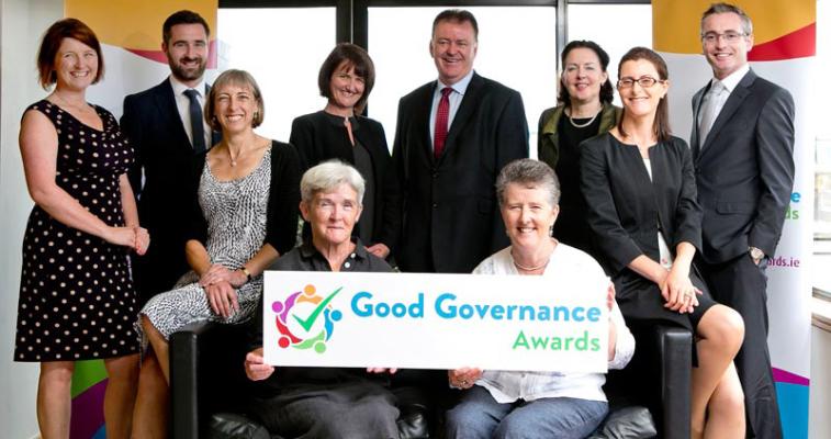 An image of a group of people holding a banner for the Good Governance Awards, representing a selection of the Judging Panel from the first year of the Good Governance Awards, 2016.