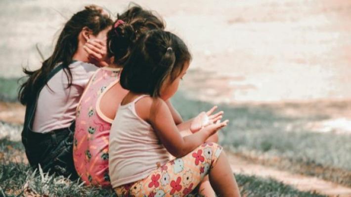 Three young girls sitting together and chatting, symbolic of the Fund.