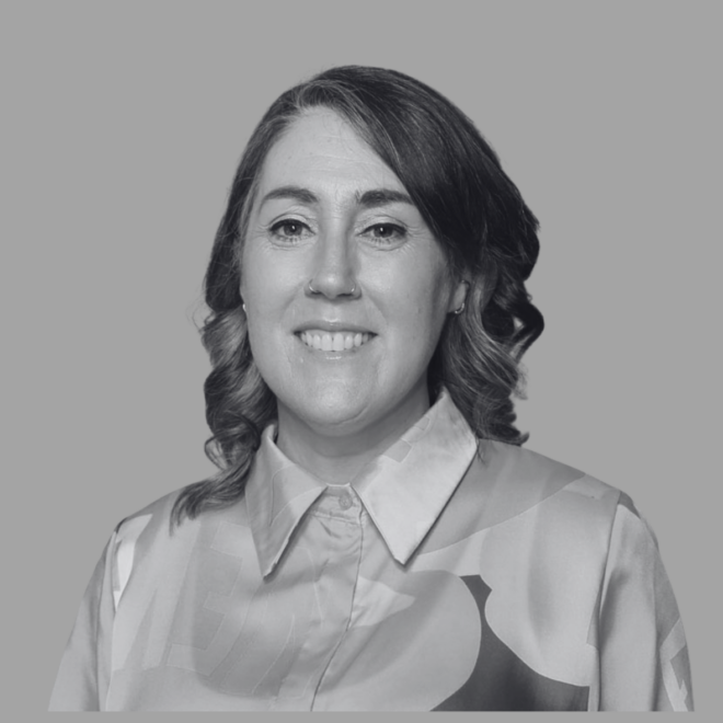 Headshot of a smiling woman wearing a collared shirt against a plain background.