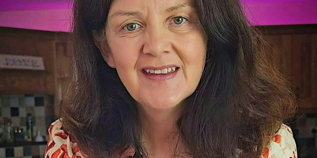 A woman with dark shoulder-length hair smiling at the camera as The Wheel invites organisations to take part in its pay and benefits survey.