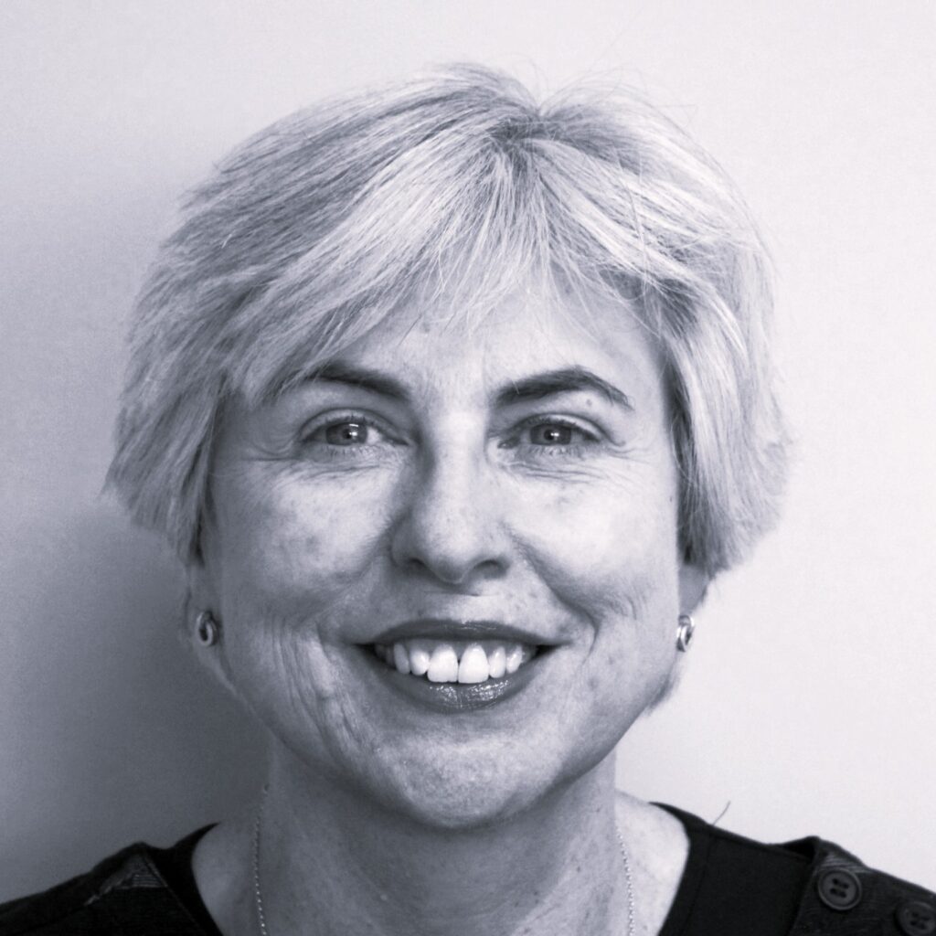 Headshot of a smiling white woman with short, light-coloured hair.